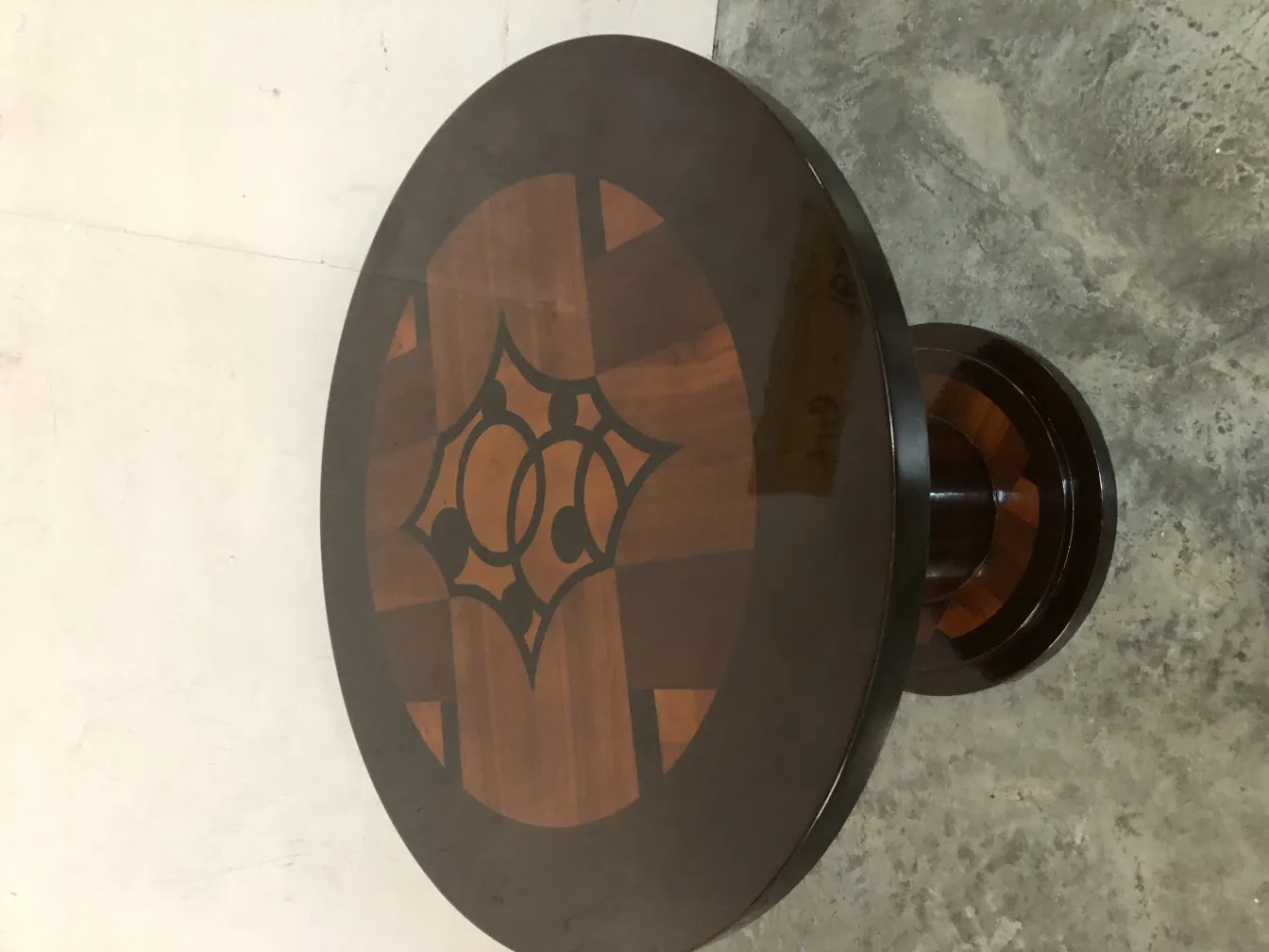 petite table ovale ancienne avec un design compliqué sur la surface, fond clair