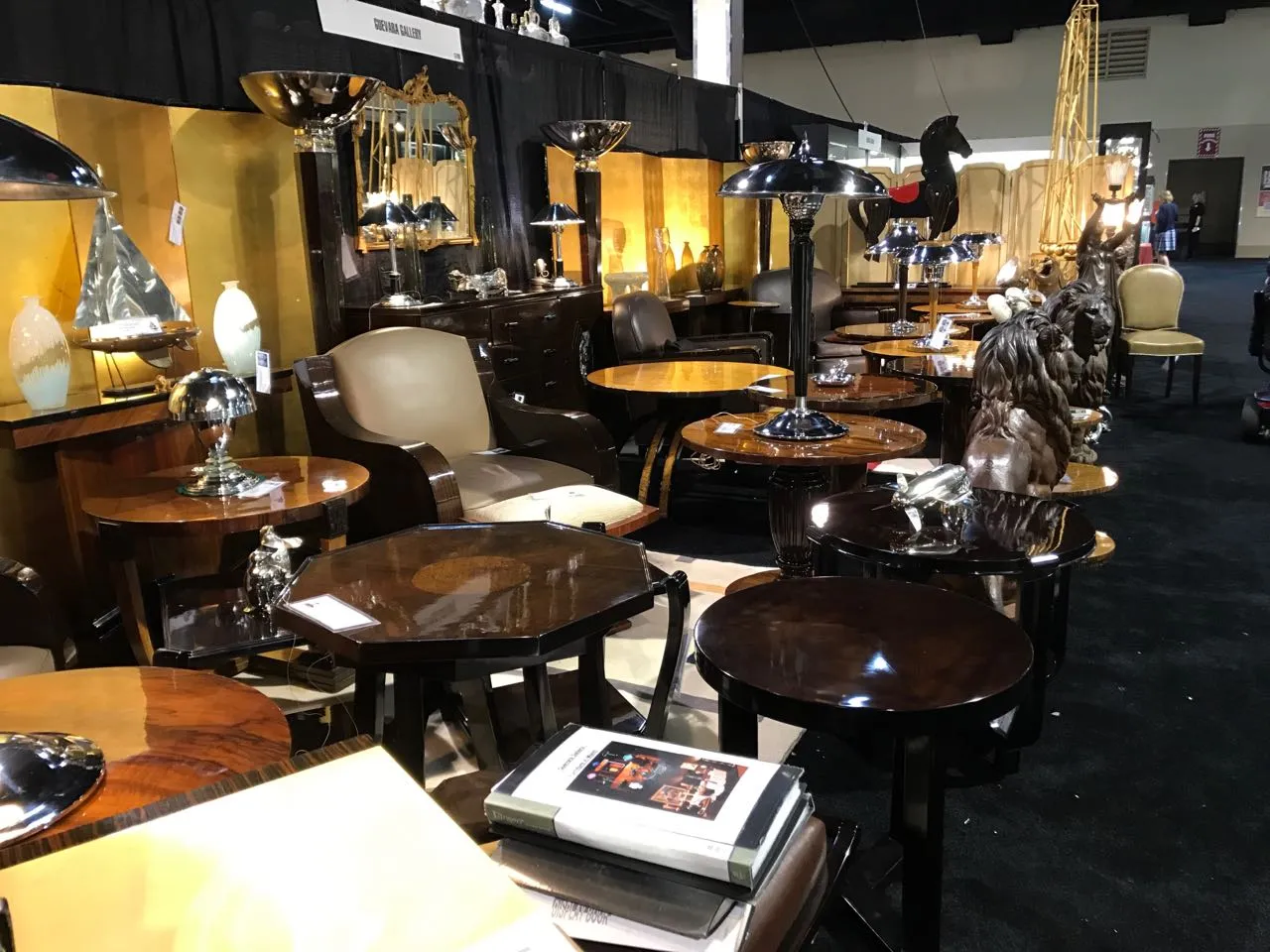 Антикварный маленький столик с декоративными элементами, окруженный другими предметами мебели