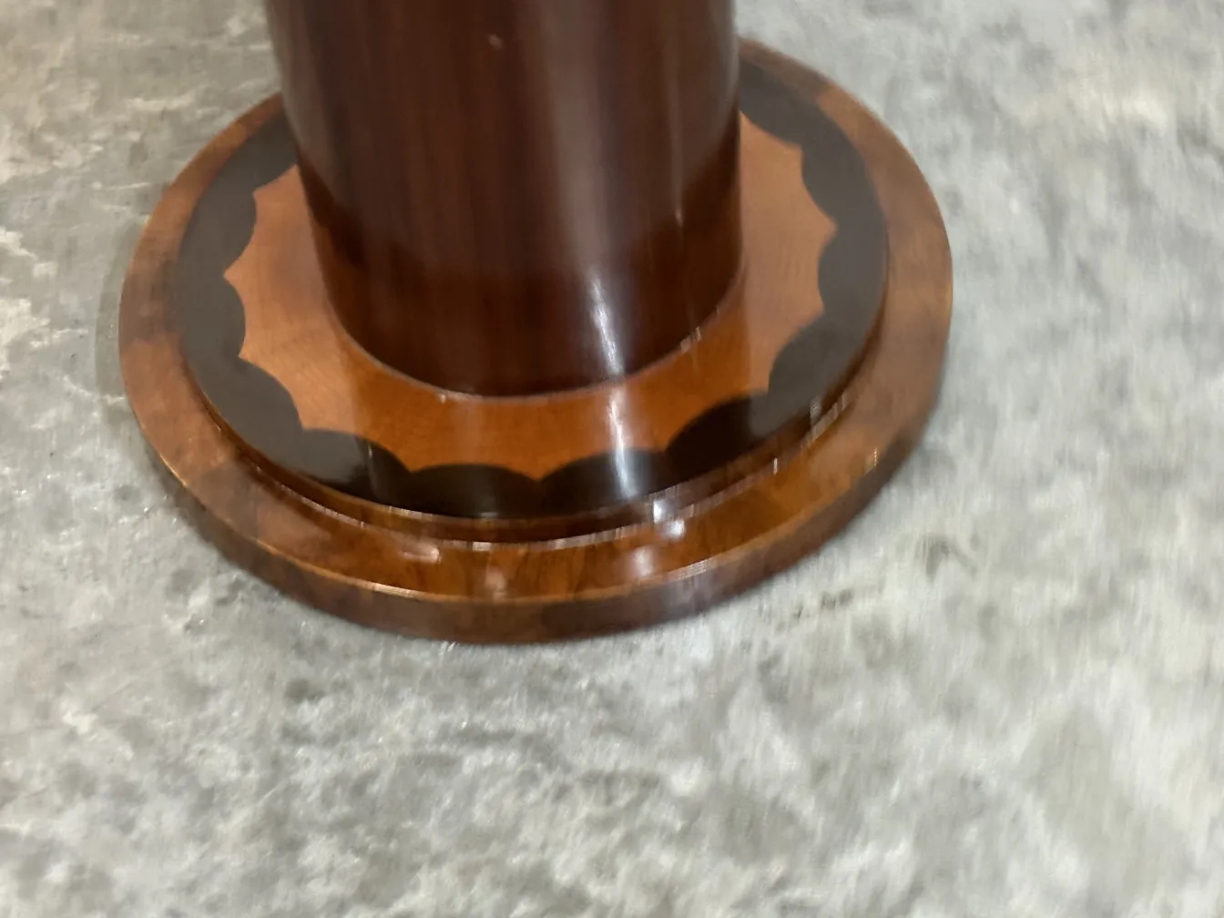 Détail de la base d'une petite table ancienne, avec un design élégant et courbé