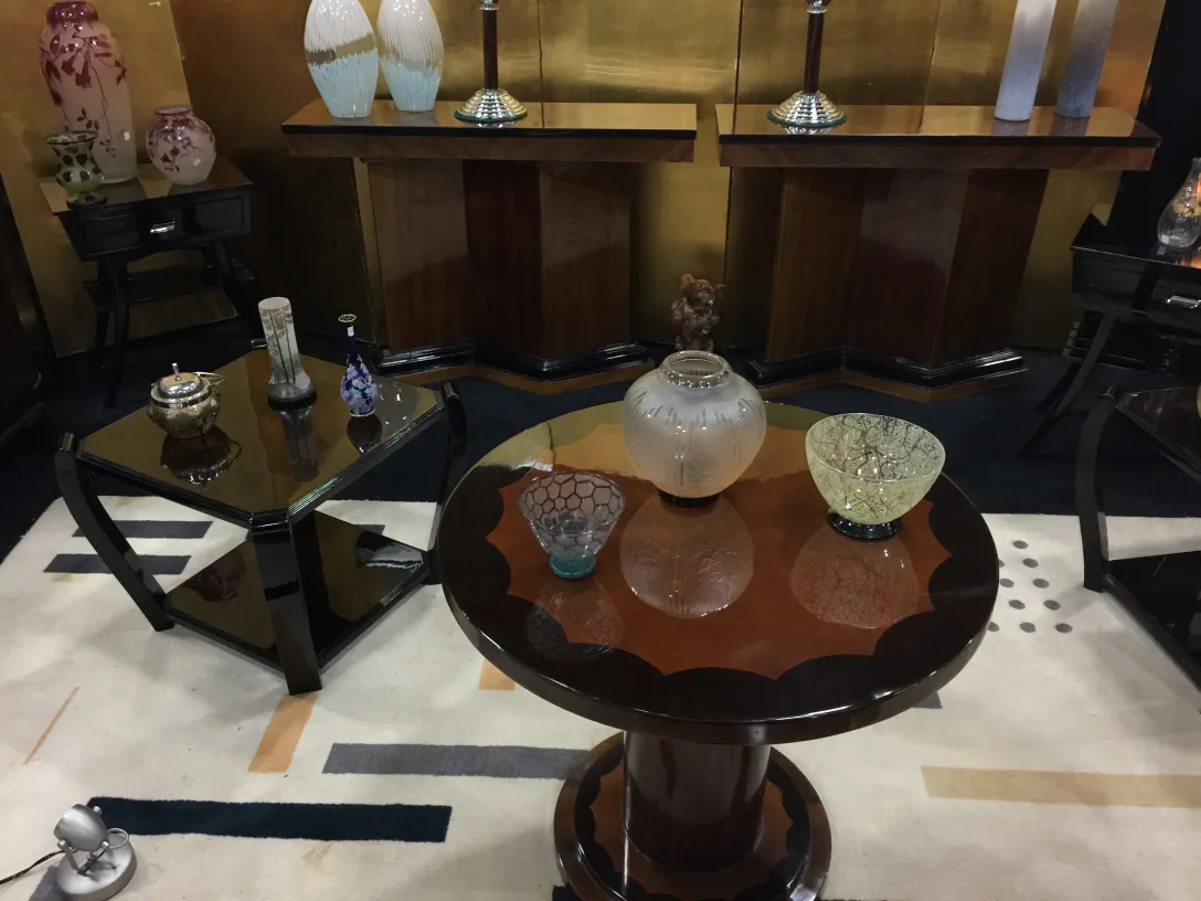 Mesita antigua de salón con estilo elegante, acompañada de decoraciones como jarrones y objetos de arte.