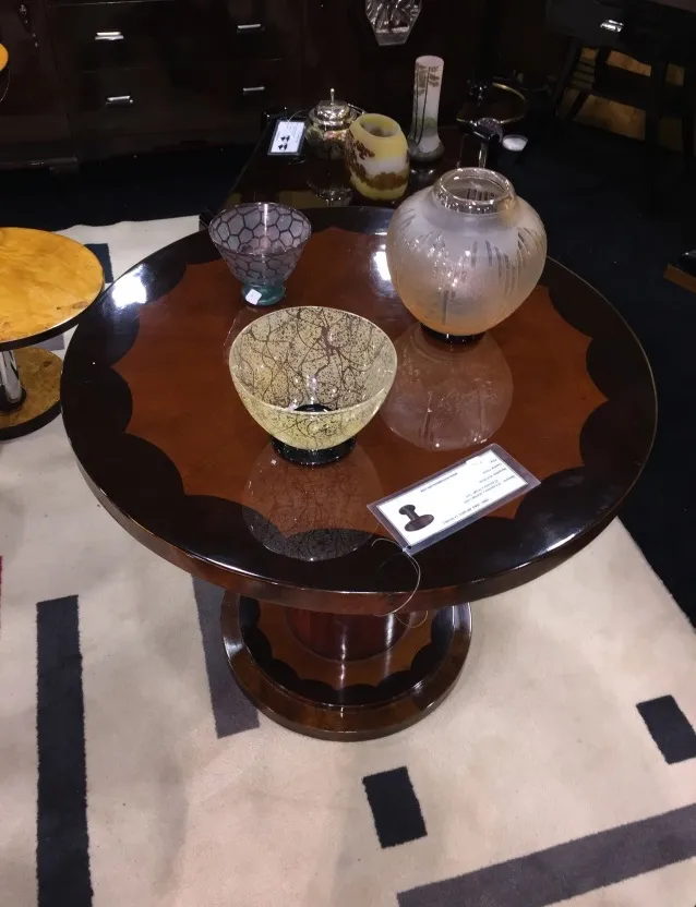 petite table ronde ancienne avec des décorations et des vases