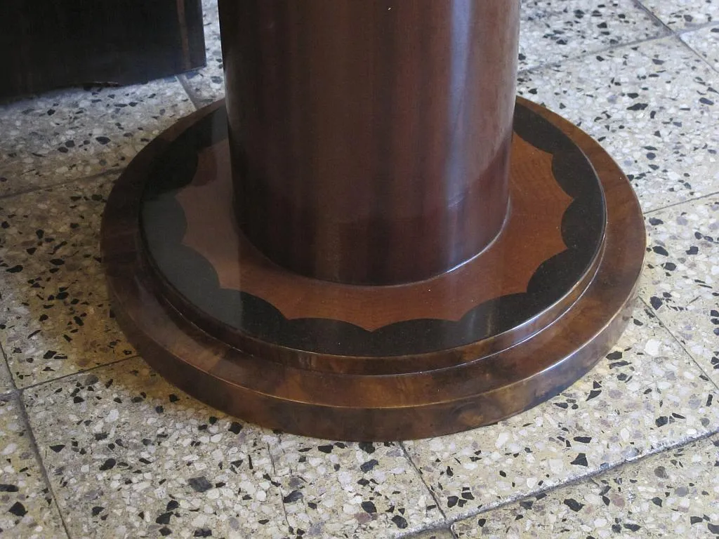 detalle de la base de una antigua mesita redonda con un pie decorativo