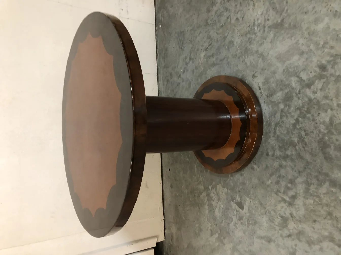 Antique small table with round base in a neutral setting