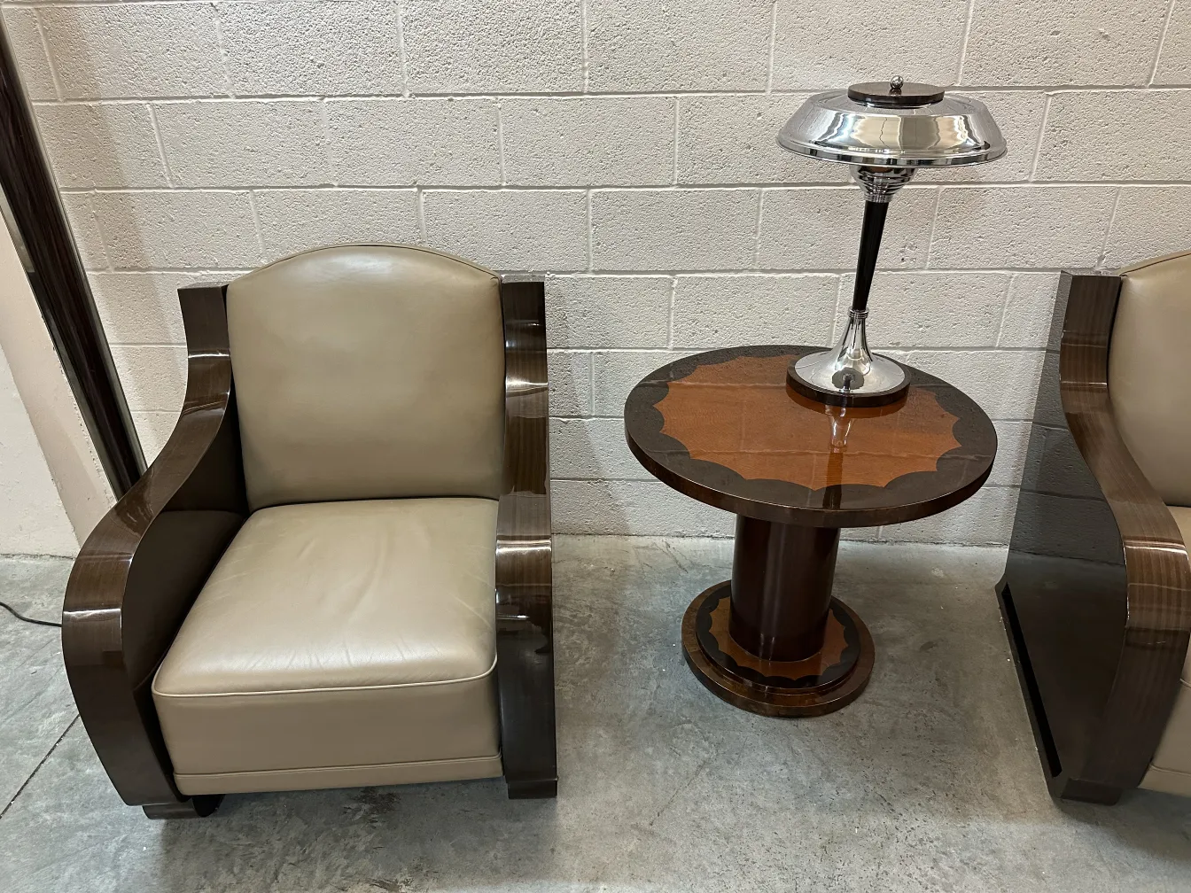 petite table ronde antique avec décoration en haut, à côté d'un fauteuil