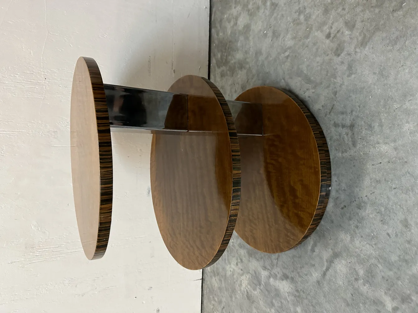 Petite table antique à deux niveaux, fond simple et élégant.