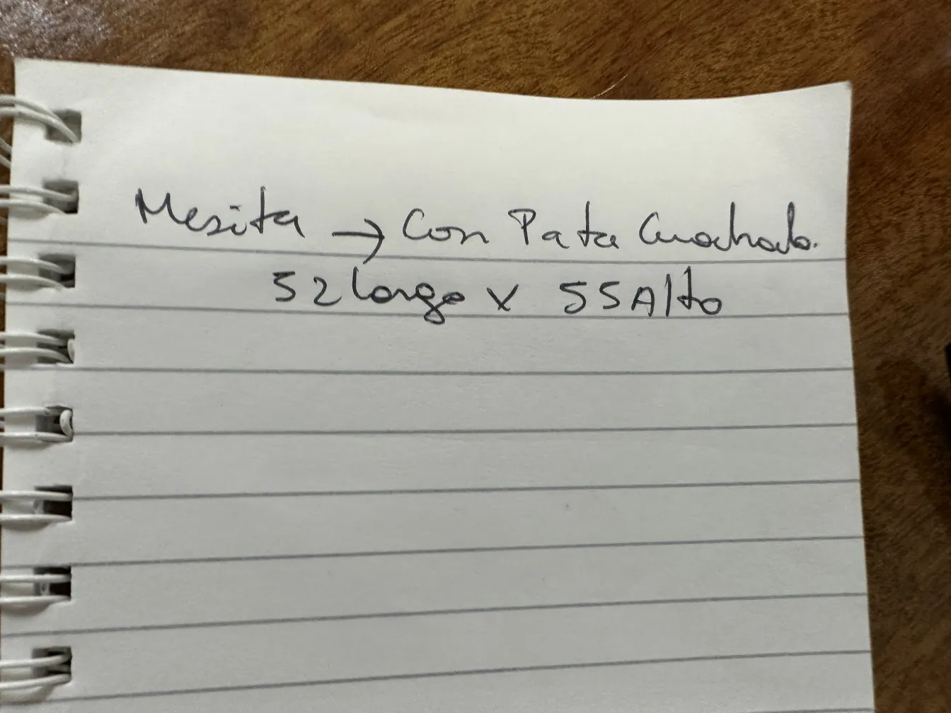 Mesinha antiga com perna curvada em ambiente aconchegante.