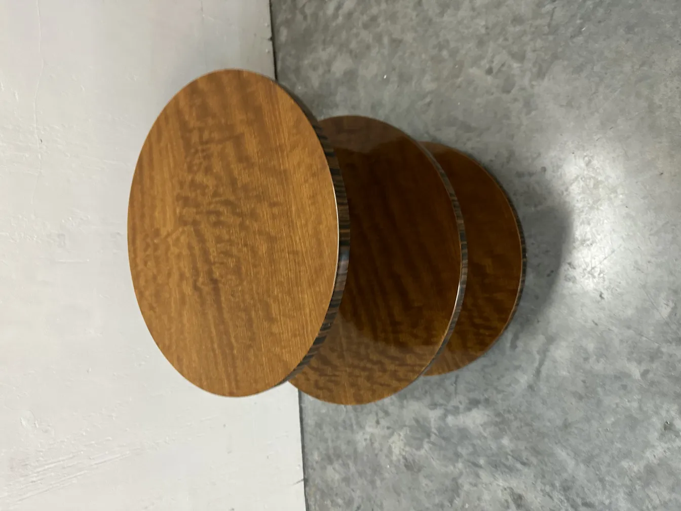 Antique round small table with a smooth design, placed in a modern setting.