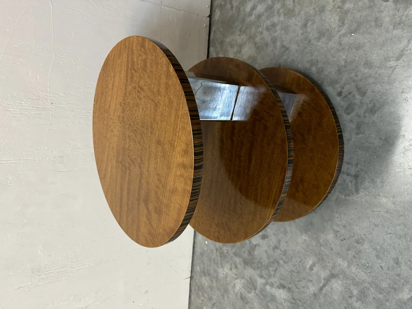 Petite table ancienne ronde à trois niveaux dans un environnement neutre