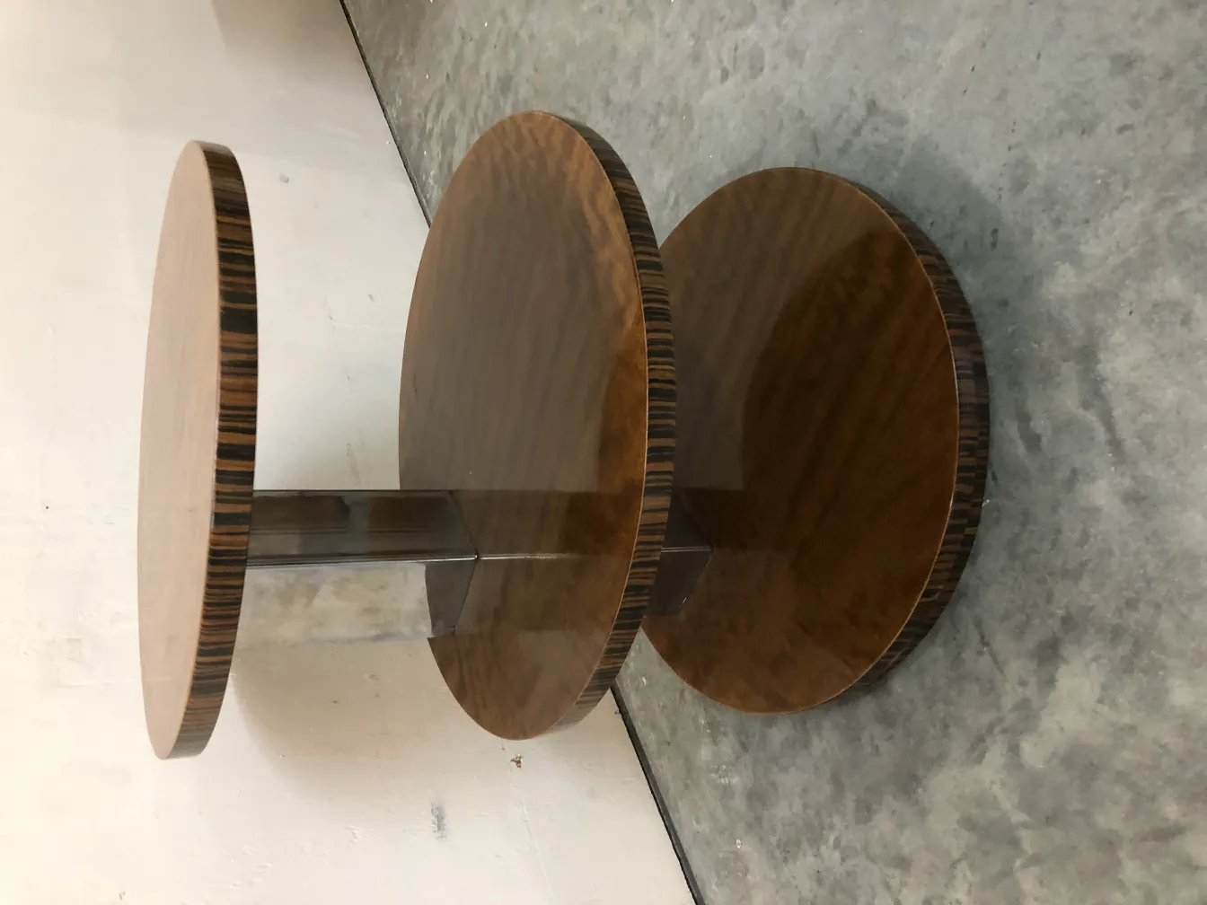 Antique small table with round design and metal base in minimalist setting.