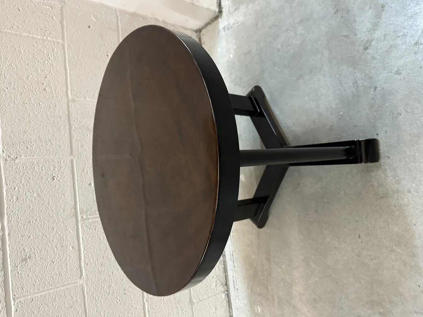 antique round small table with dark surface and sturdy legs