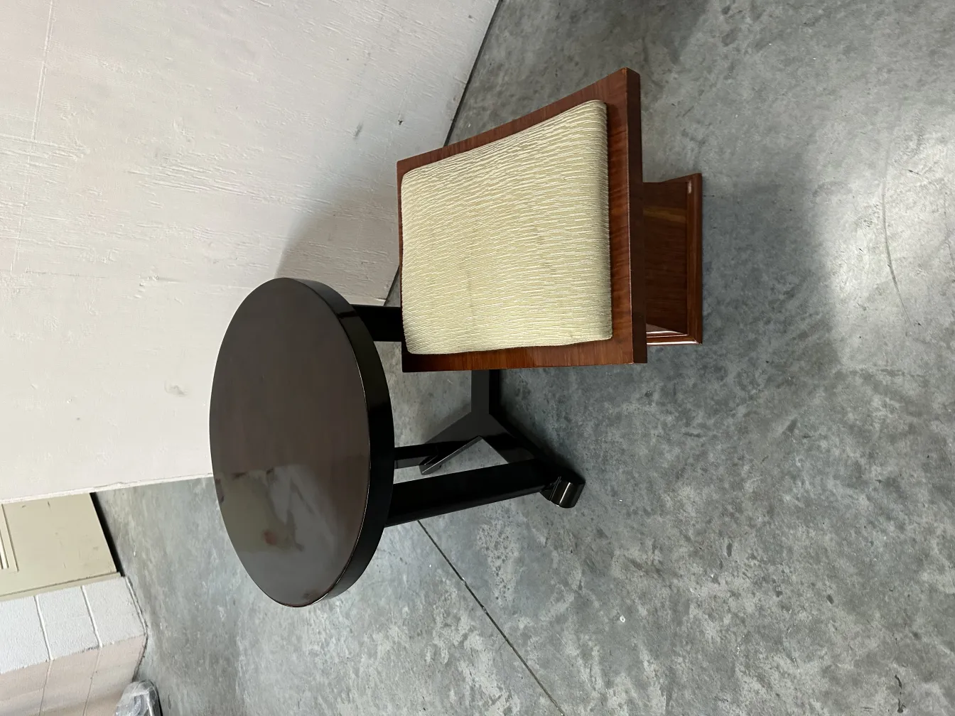 mesita antigua redonda con silla de cojín claro