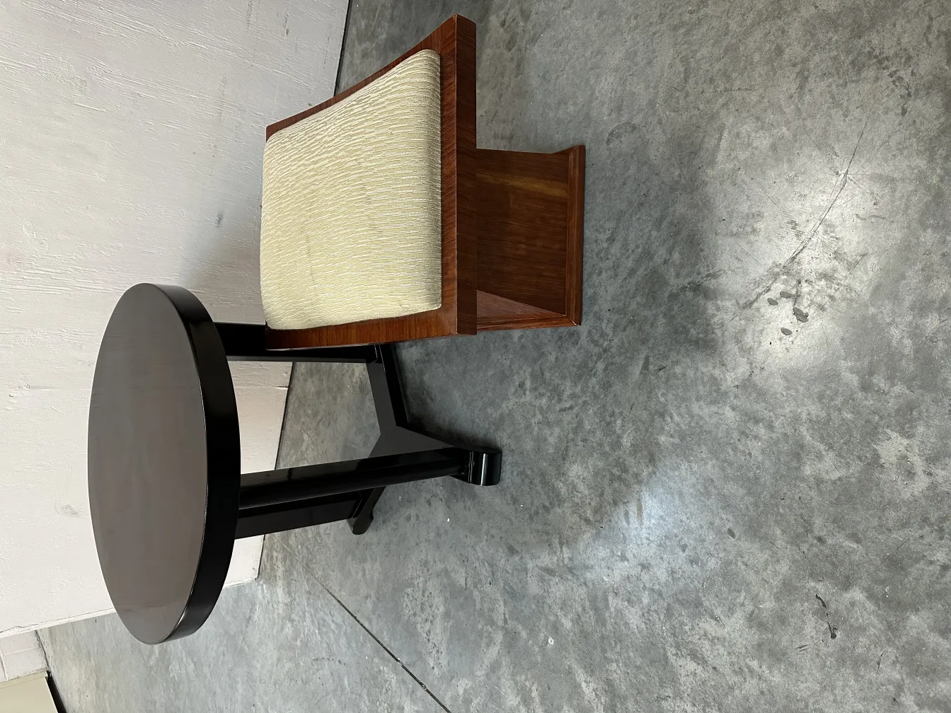 mesita antigua redonda con diseño elegante y suave tapizado claro, ambiente acogedor