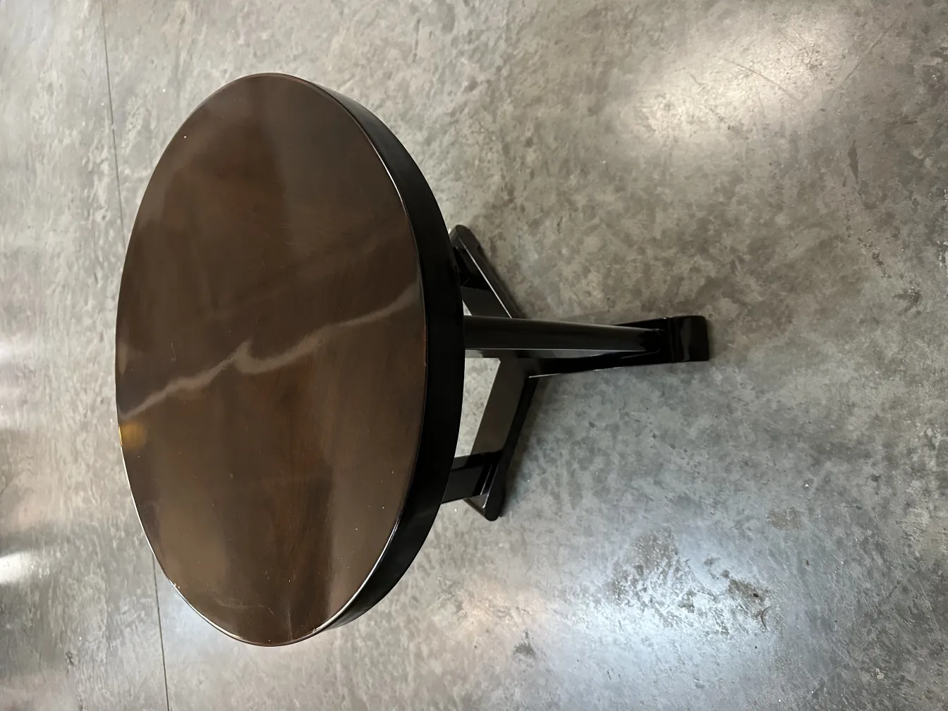 Round antique small table with black legs in a modern setting