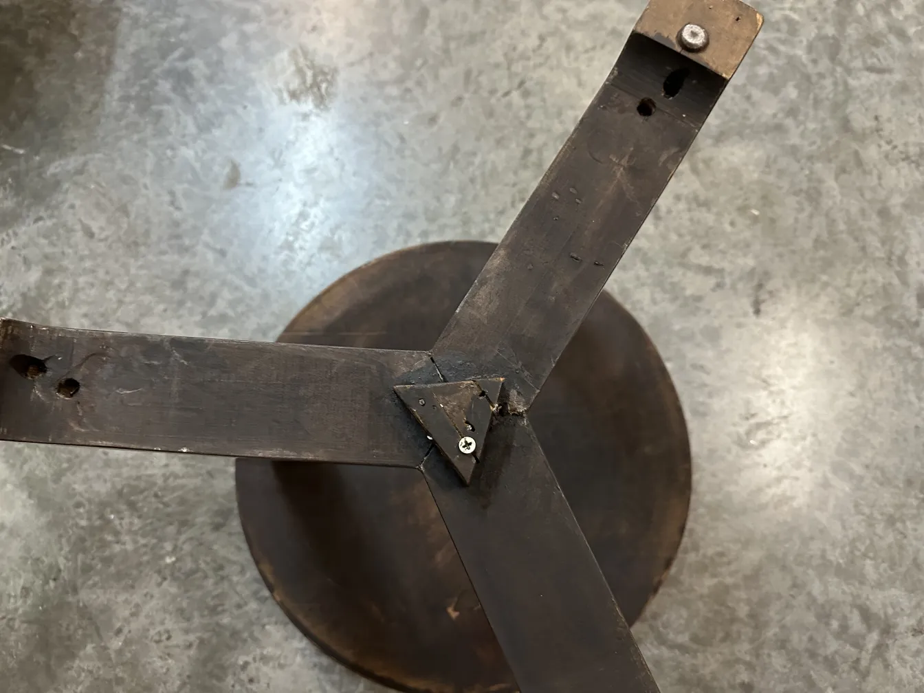 Vue de dessus d'une petite table ancienne avec une base ronde et des supports en métal