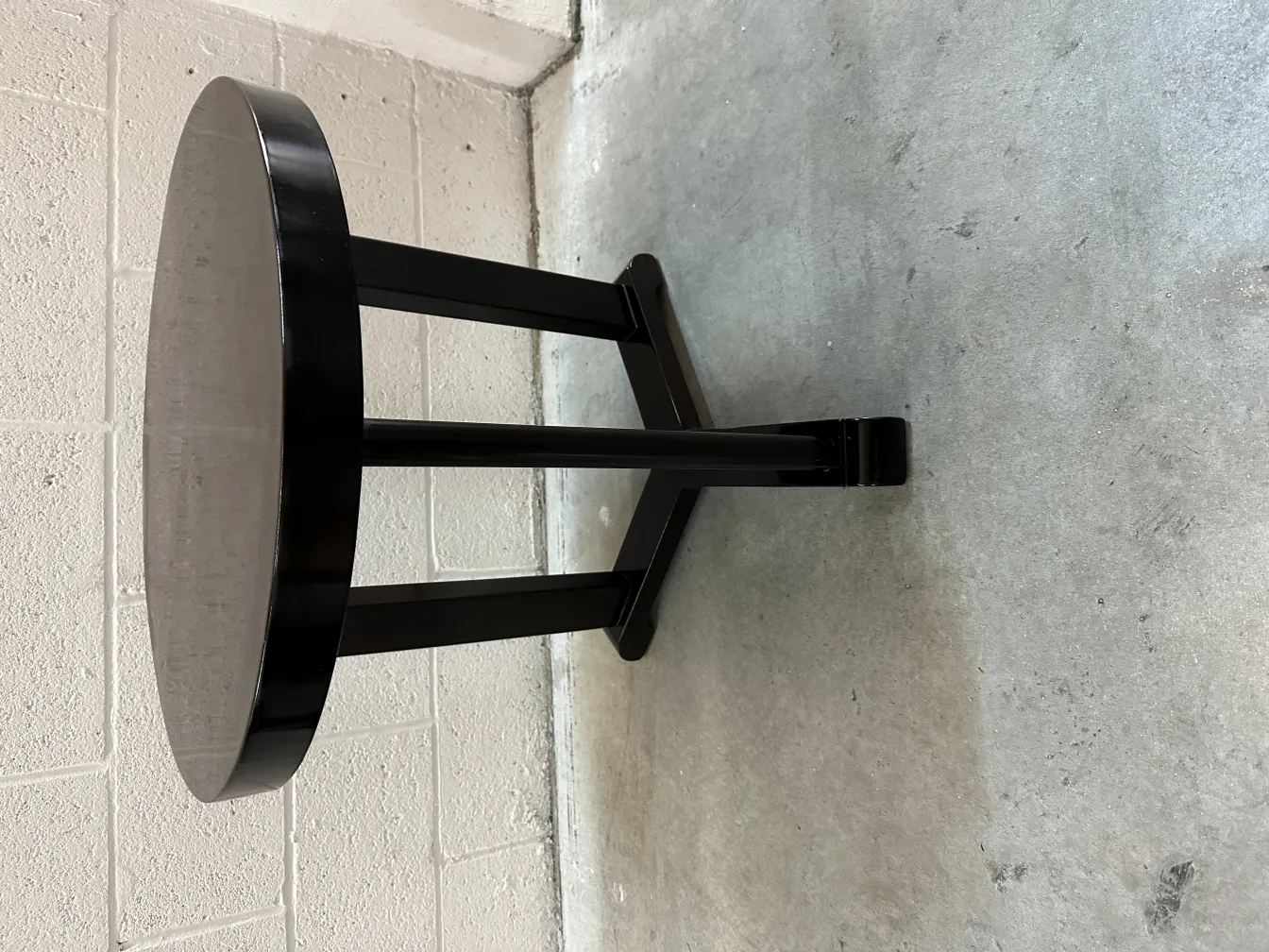 antique small round table with black legs in neutral setting