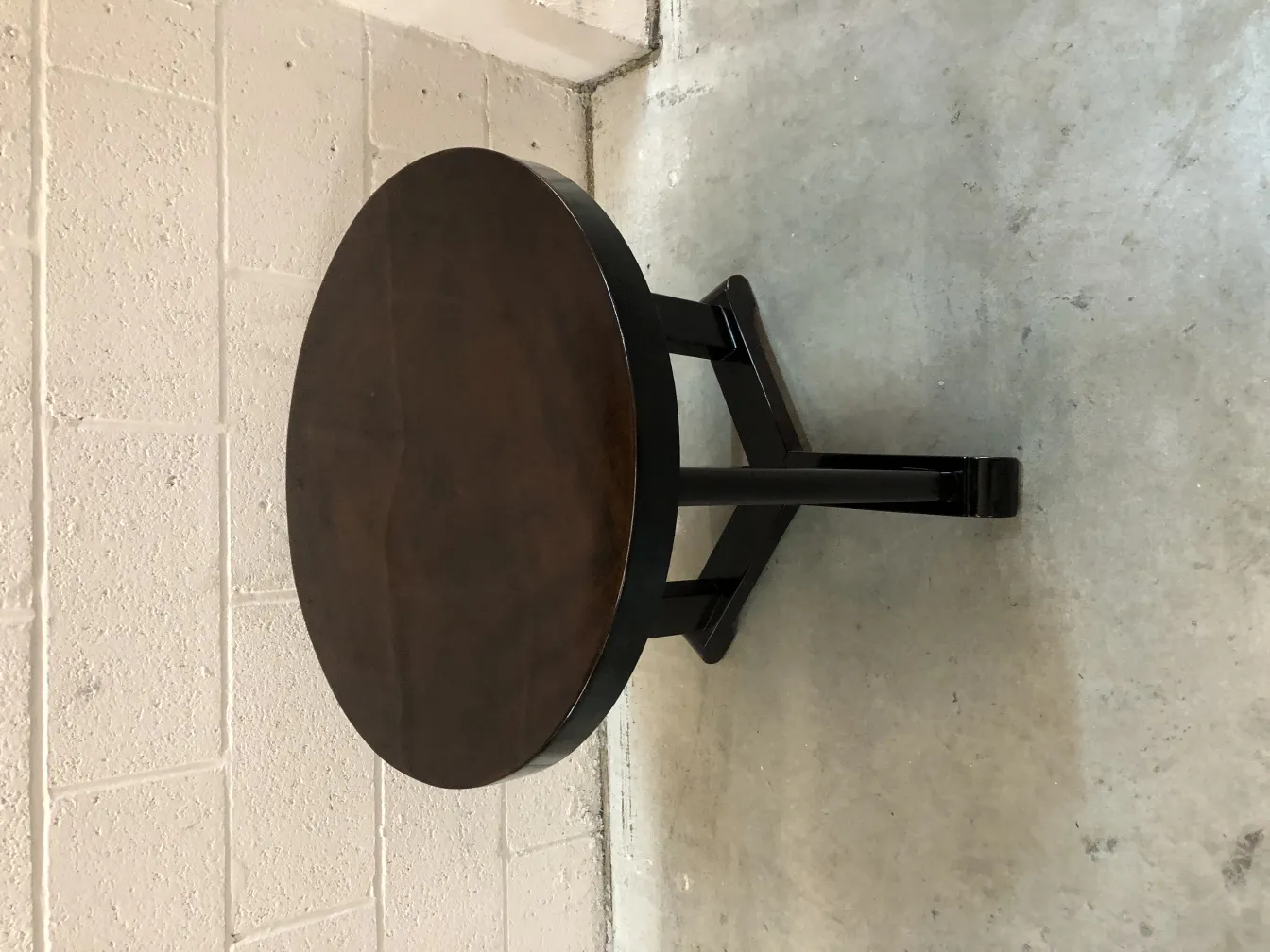 Small antique round table in a neutral setting.