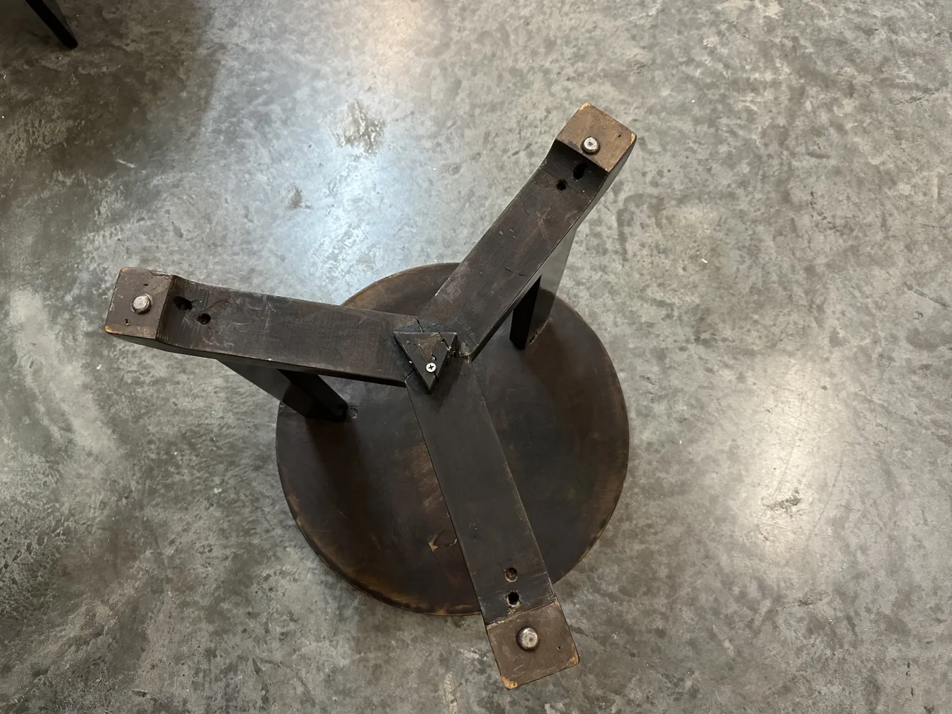 antique round small table with visible legs and screws