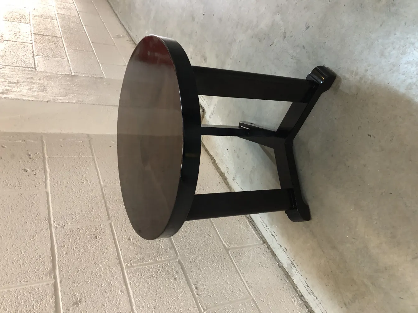 table ronde ancienne avec finition sombre dans un cadre moderne