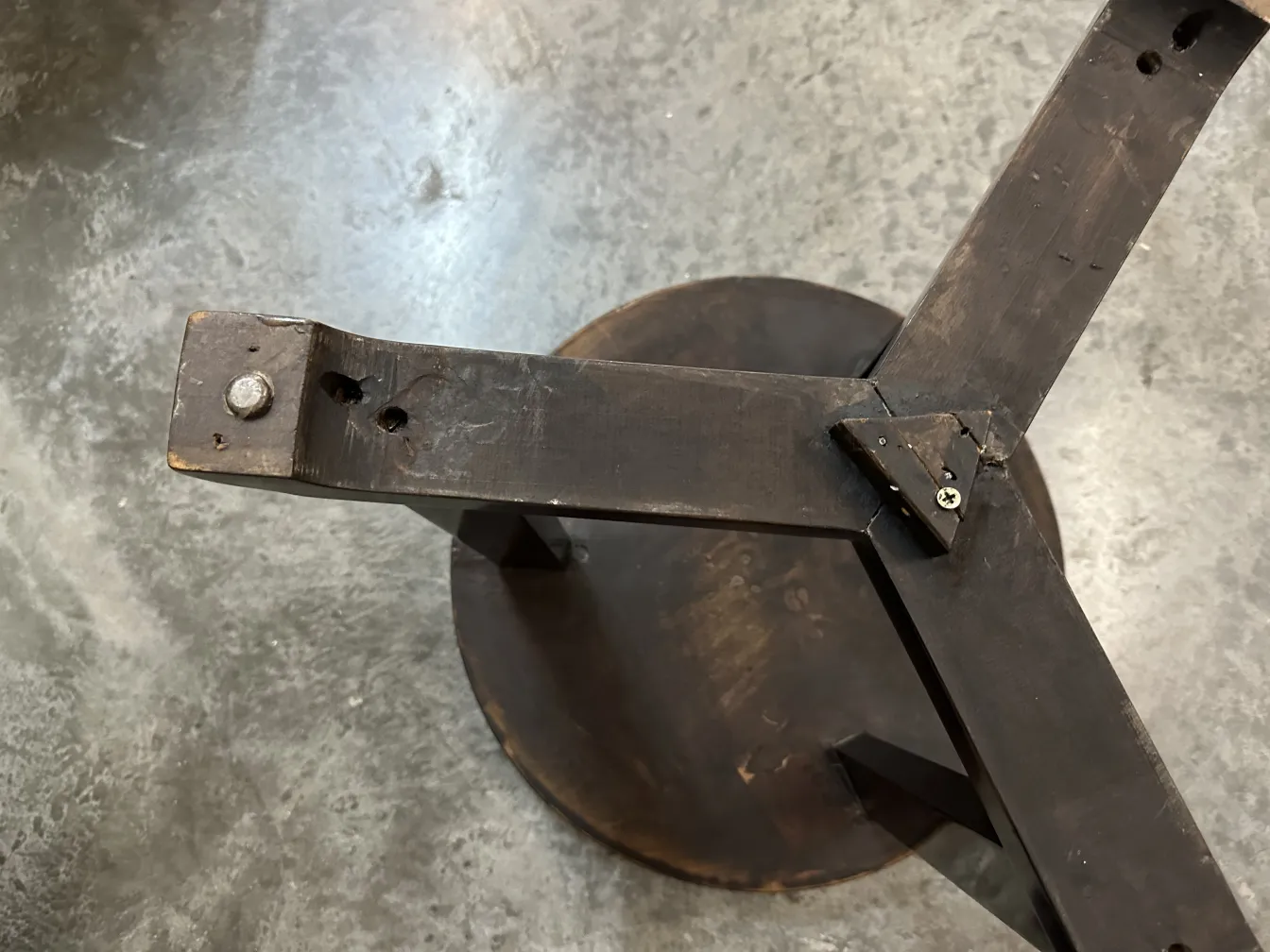top view of an antique small table with a round base and cross-shaped legs