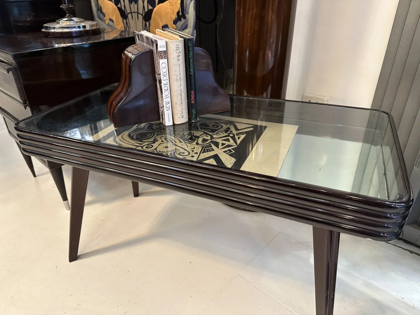 Antique bookends in Art Nouveau style, complementing an elegant piece of furniture. Books arranged neatly with an attractive design.