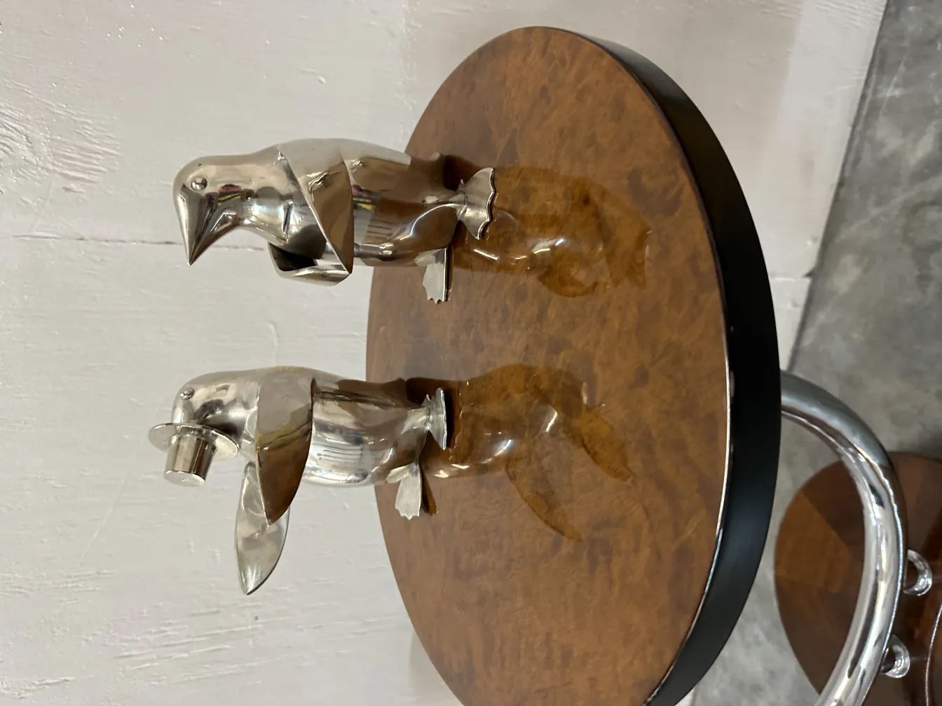 Tavolino antico con figure decorative. Superficie marrone e sfondo bianco.