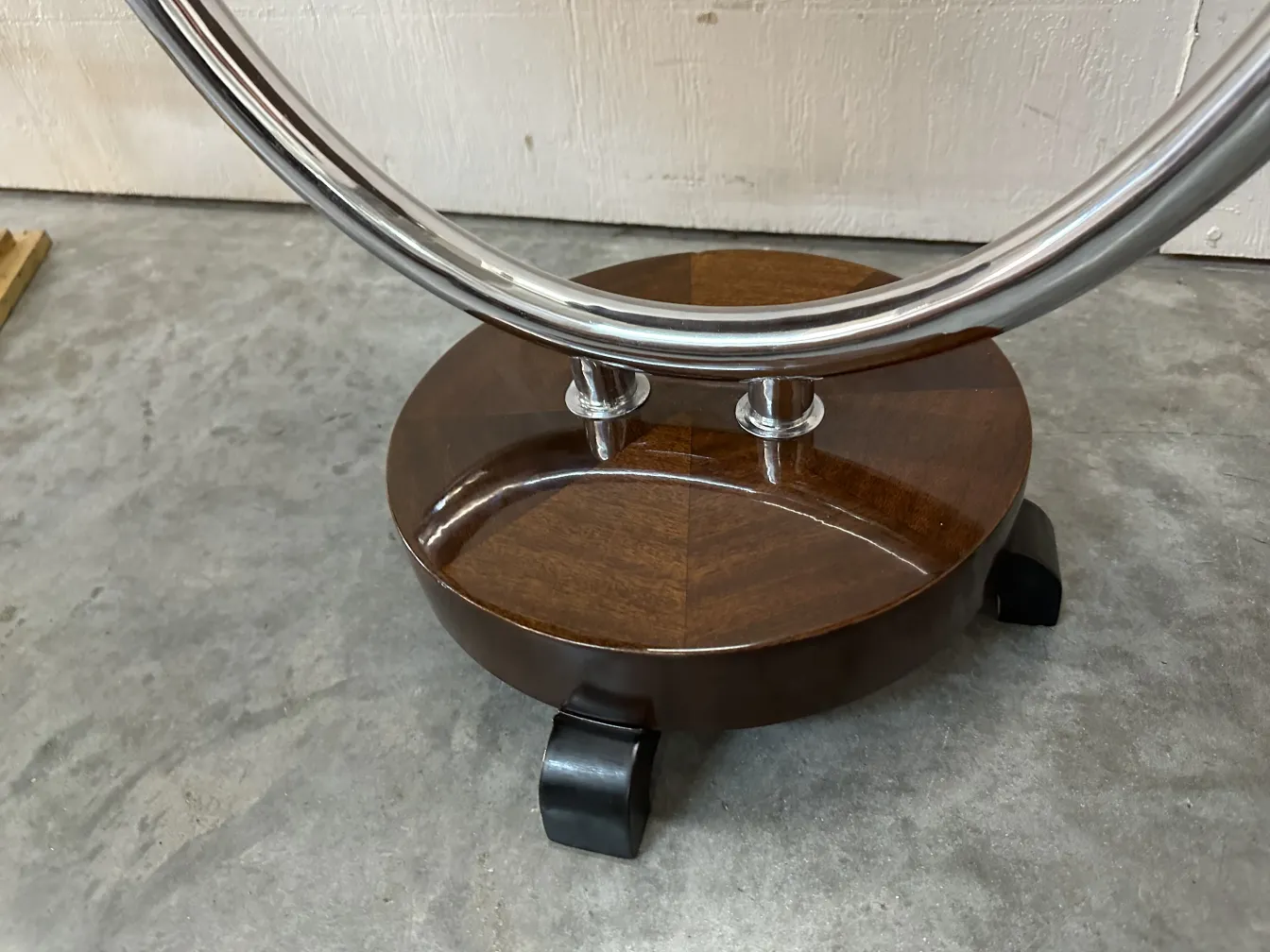 mesinha antiga com base curva e rodinhas, ambiente neutro