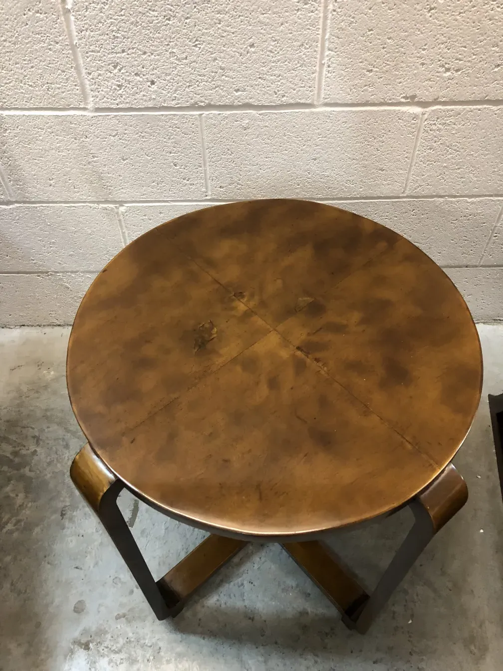 petite table ancienne ronde avec une surface lisse dans un cadre simple