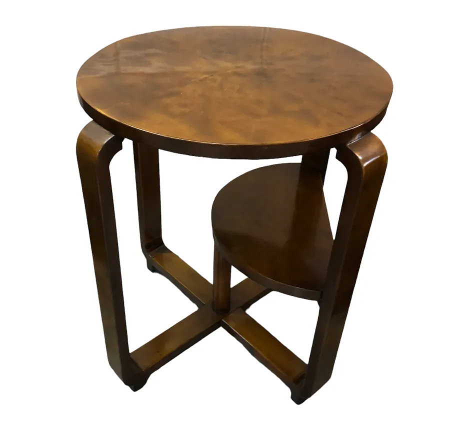 mesita antigua redonda con base elegante en un ambiente acogedor