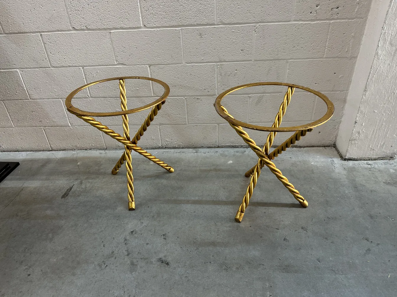 Due tavolini dorati antichi con design attorcigliato.