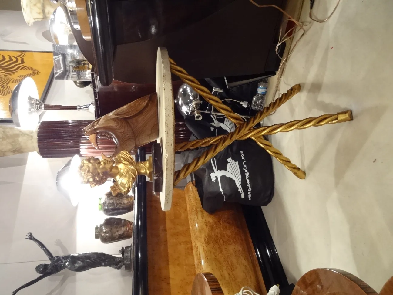 Due tavolini antichi, uno con decorazione dorata e l'altro con una base elegante, in un contesto di antiquariato