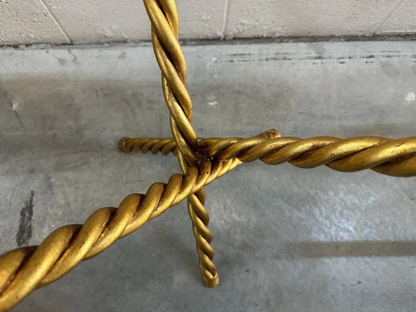 Ansicht der Beine von 2 kleinen antiken Tischen mit gedrehtem Design, vor grauem Hintergrund.