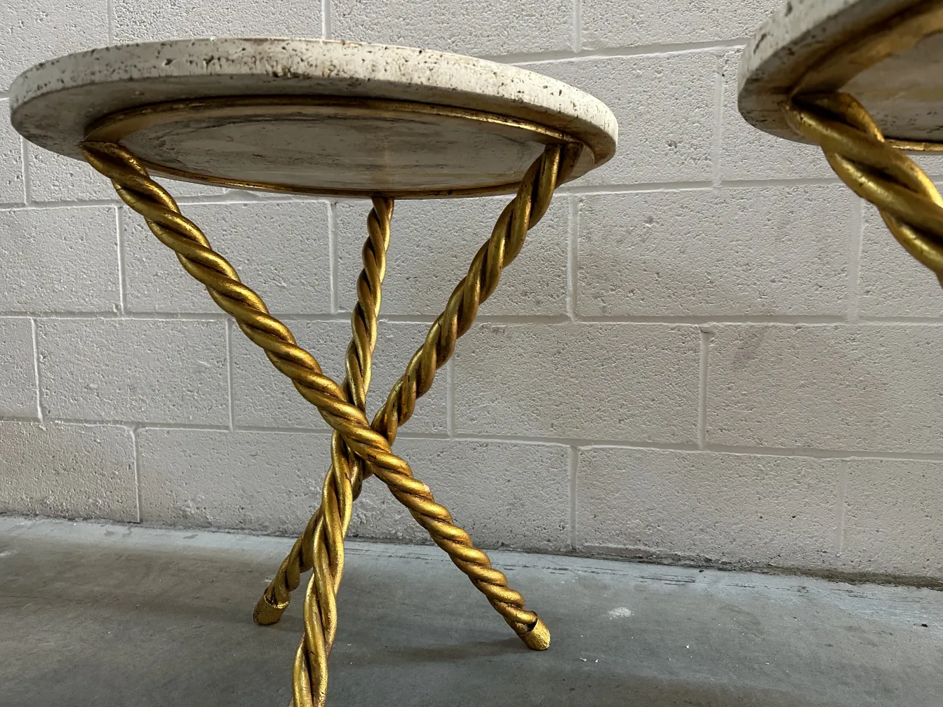 दो छोटी पुरानी मेज़ जिनके सुनहरे पैर हैं, एक शांत वातावरण में।