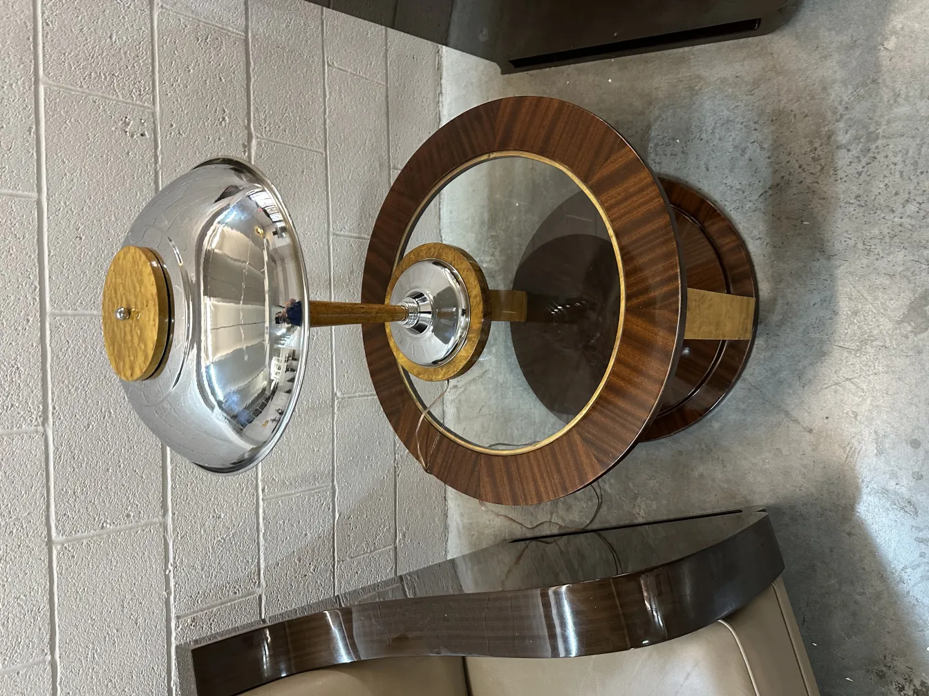 Deux petites tables anciennes rondes avec plateau en verre et détails élégants dans un cadre moderne.