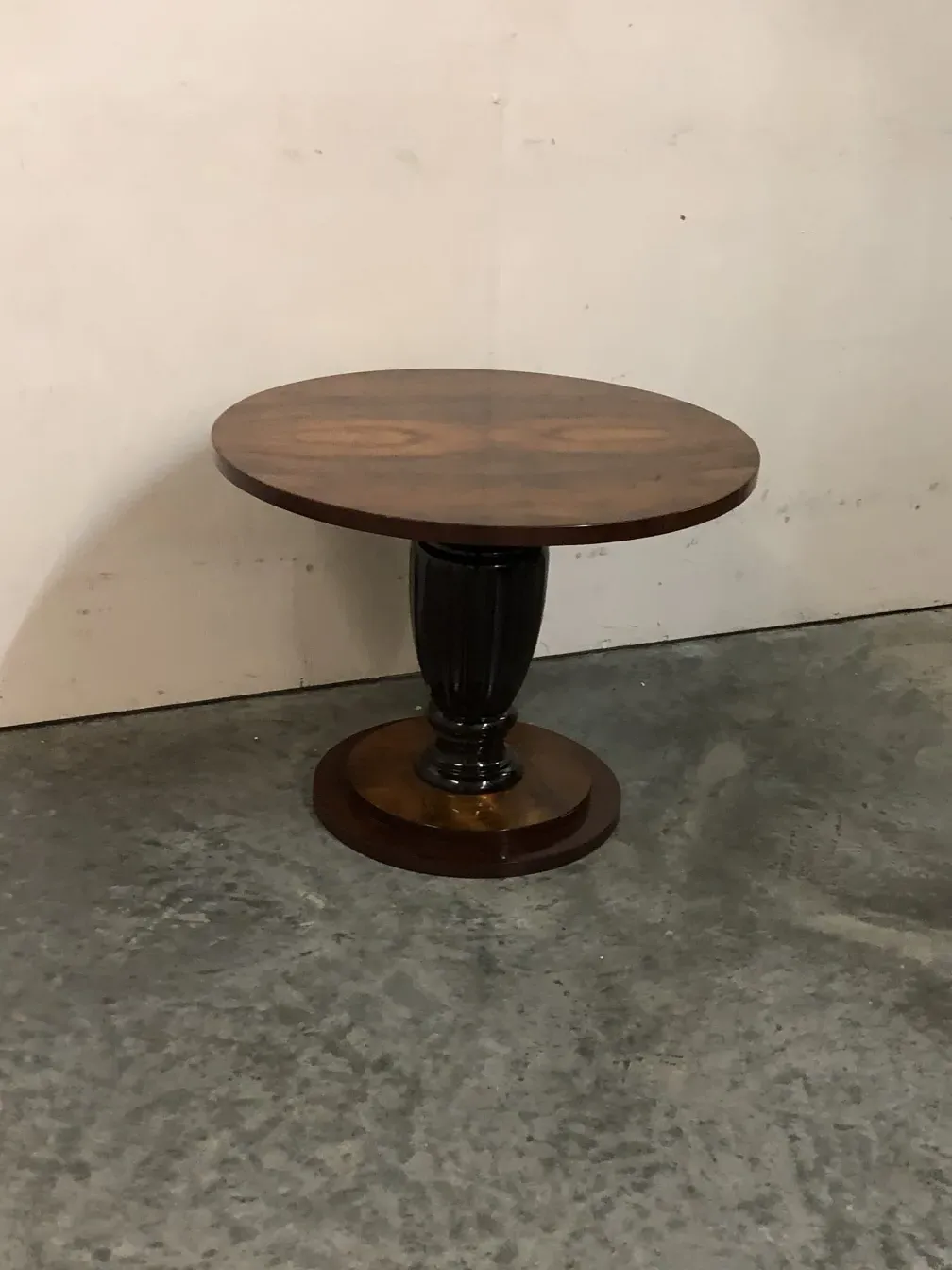 Duas mesinhas antigas com design decorativo elegante em um ambiente simples.