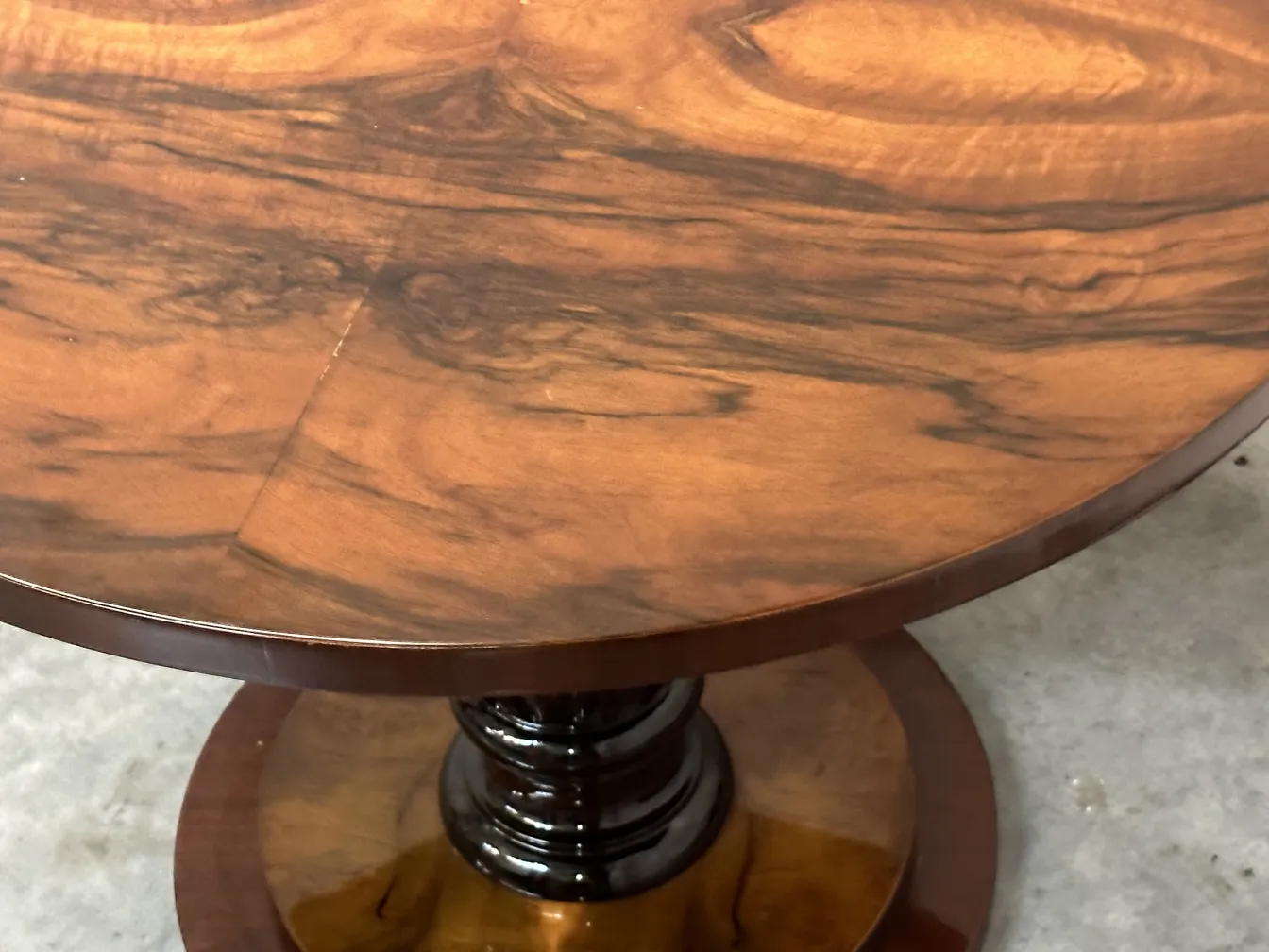 Vista de cima de duas mesinhas antigas com acabamento brilhante e detalhes elegantes na base