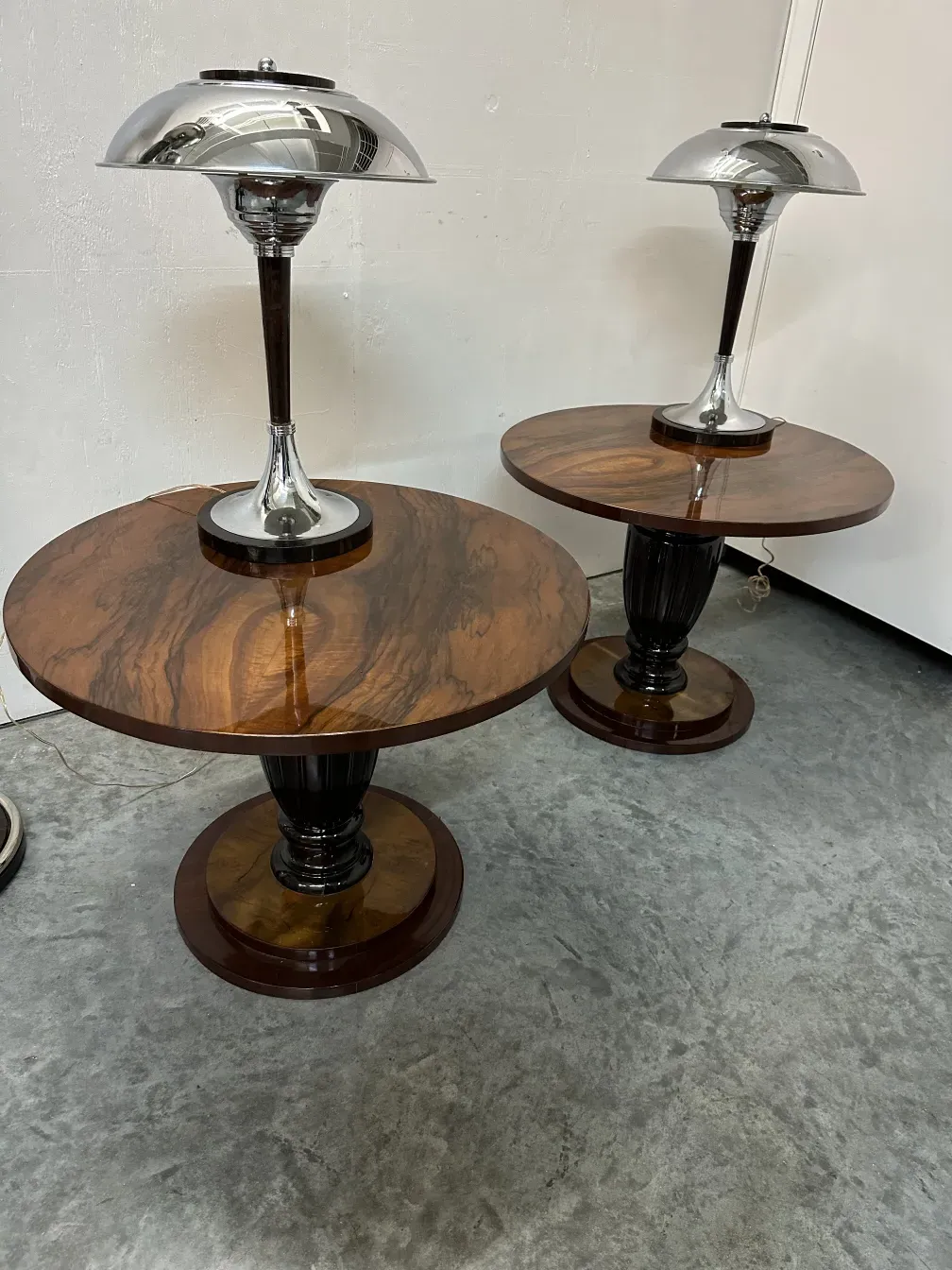 Antike kleine Tische mit runden Oberflächen und eleganten Basen in einer modernen Umgebung