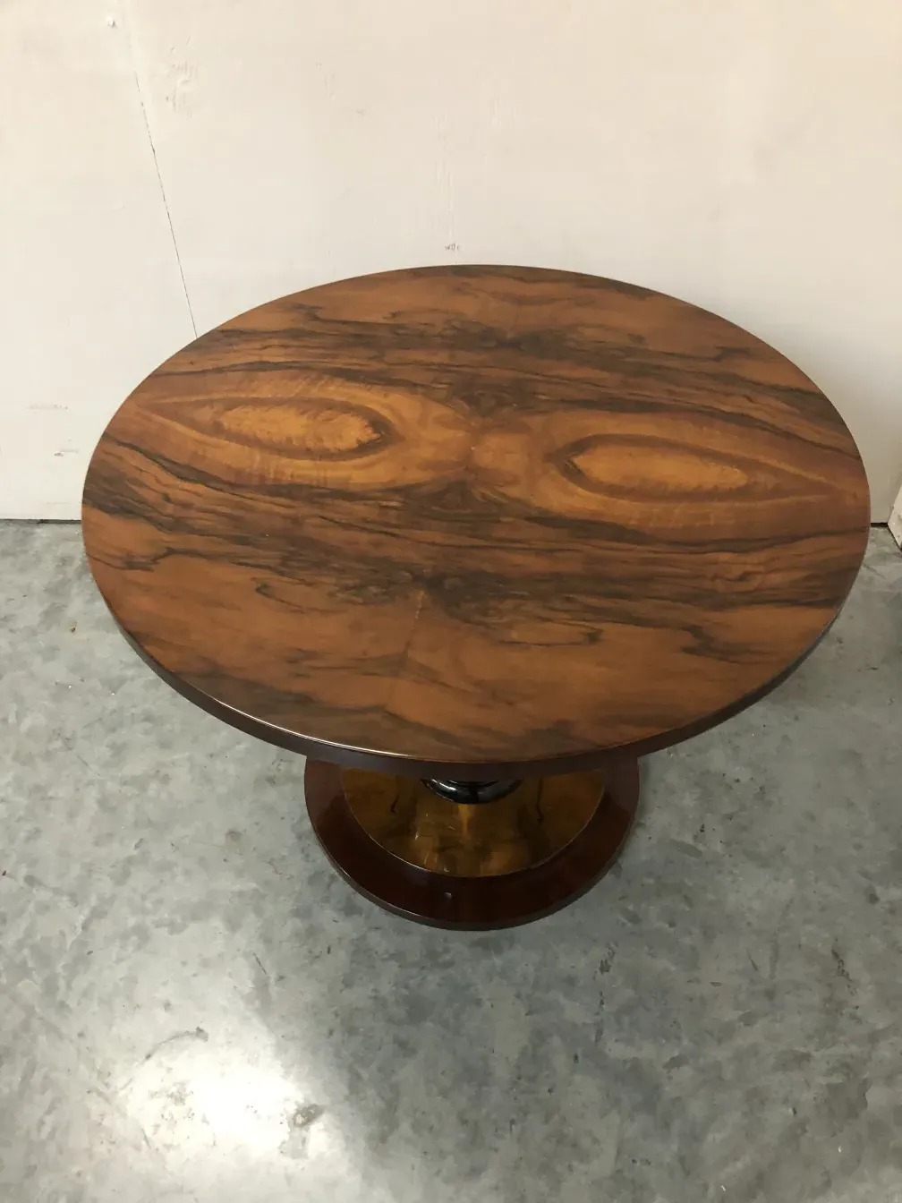 2 mesinhas antigas em formato oval em um ambiente neutro