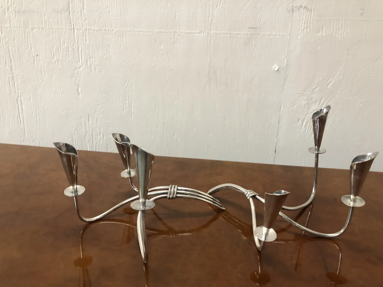 Deux candélabres anciens avec un design élégant et décoratif sur une table en bois.