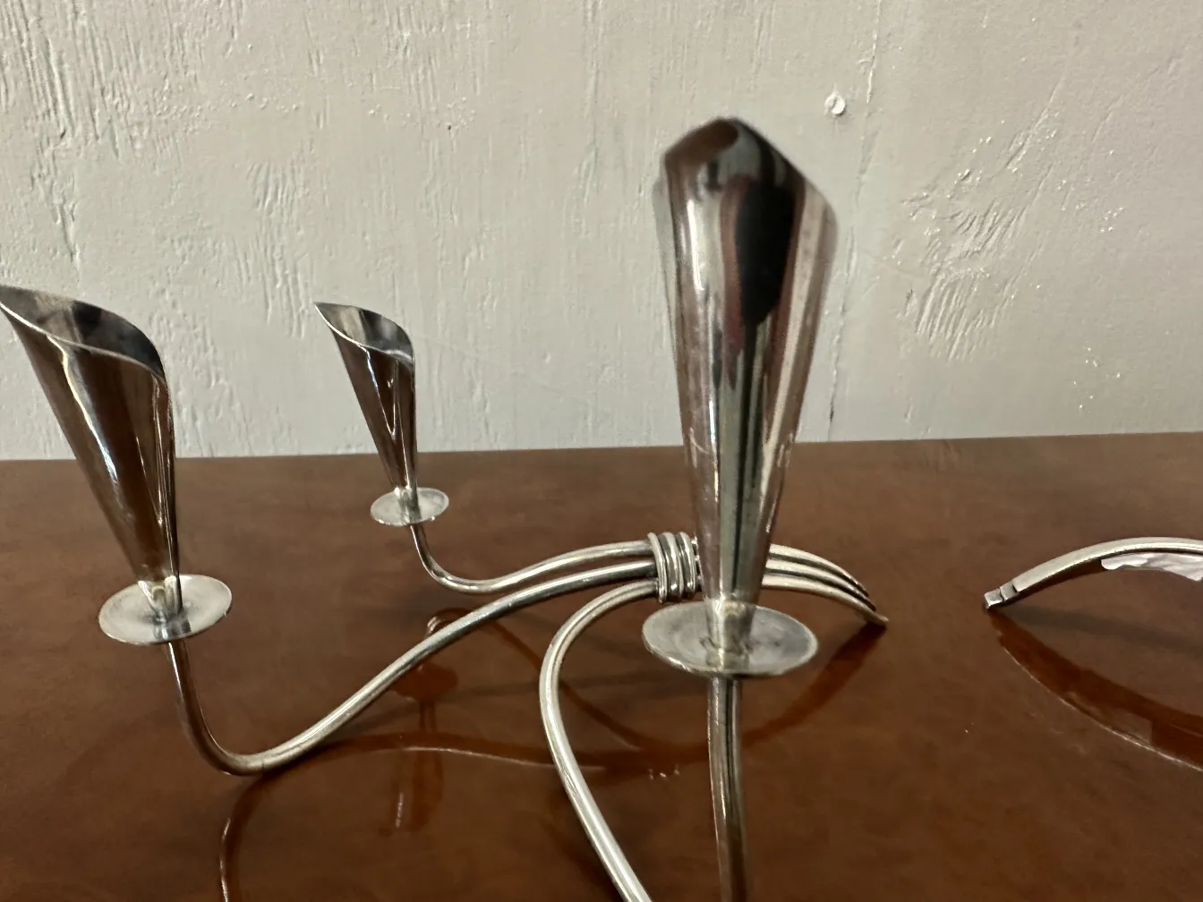 Dos candelabros antiguos con diseño elegante sobre una mesa. El ambiente es sofisticado.