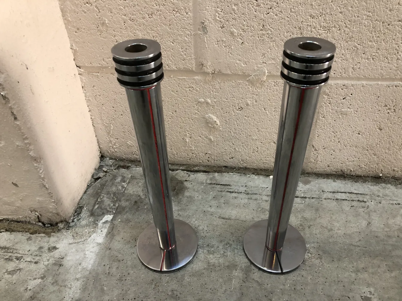 Zwei elegante antike Kerzenhalter in einer einfachen Umgebung.