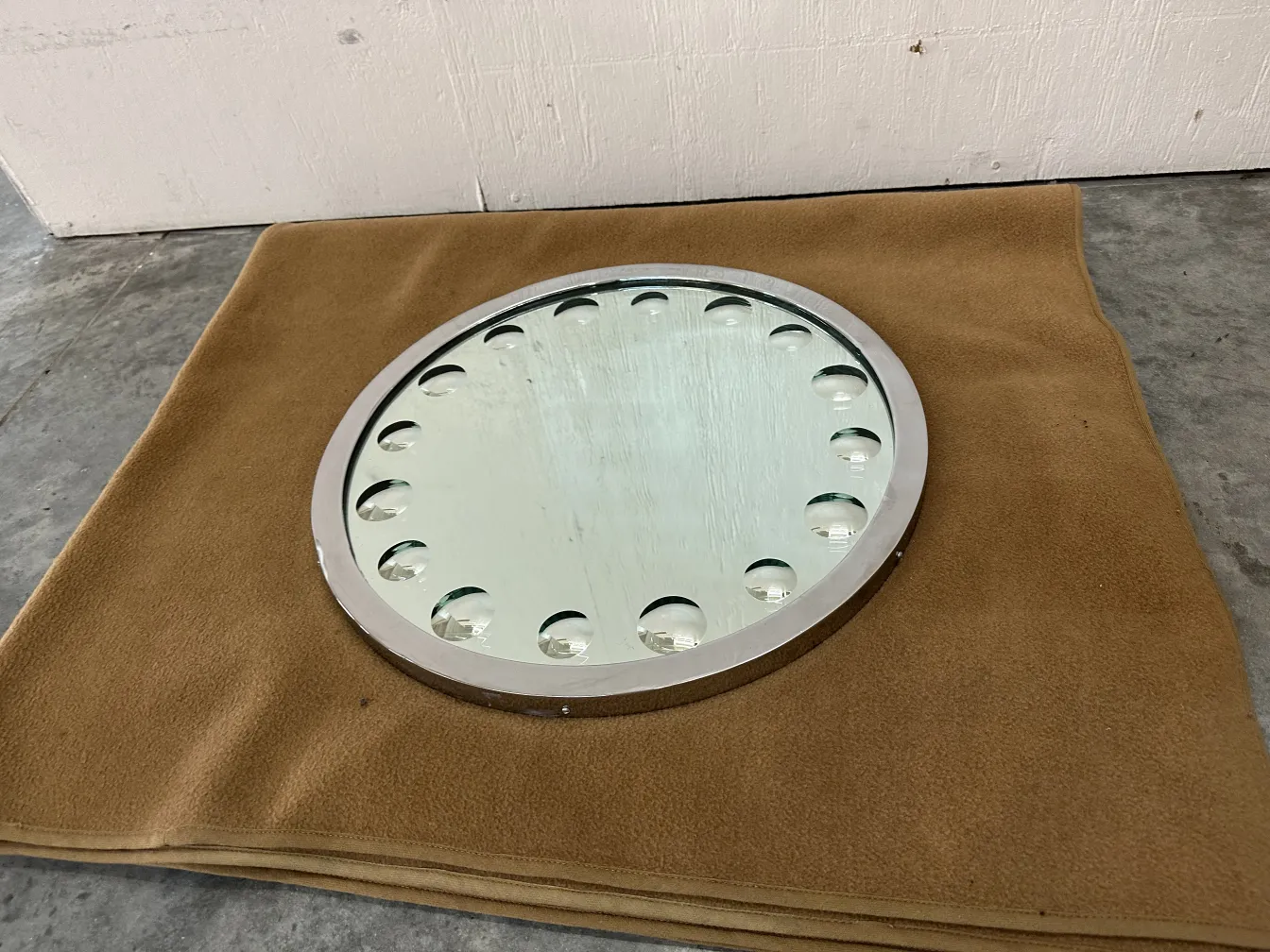 Miroir ancien rond sur fond doux avec détails décoratifs.