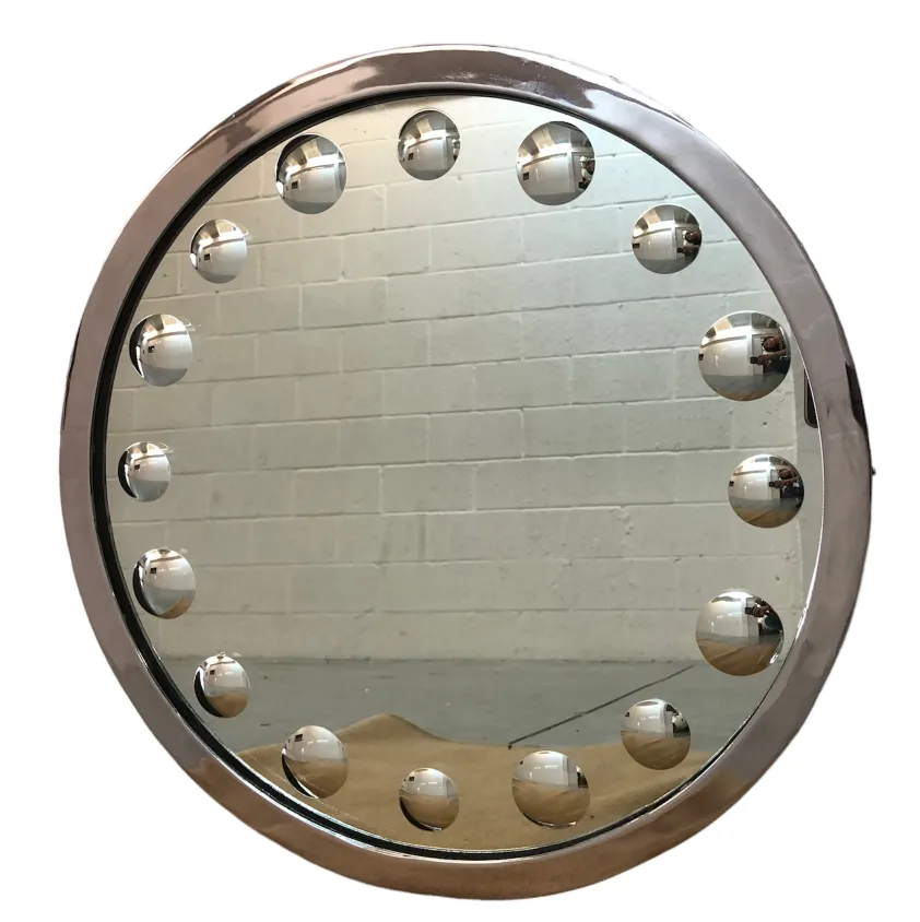 Round antique mirror with spherical details on the edge, bright background.