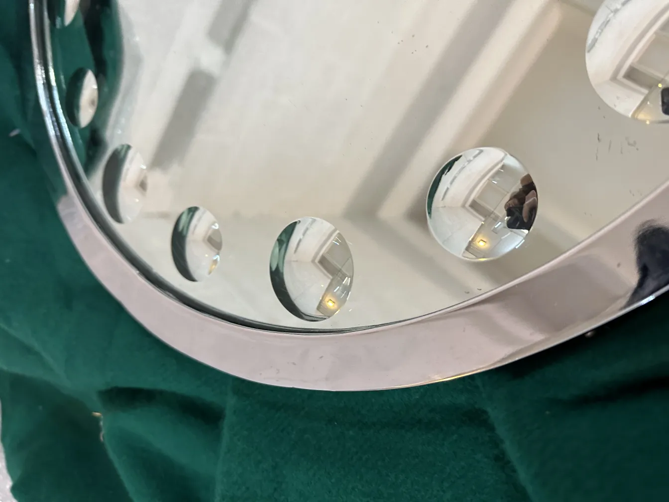 Espelho antigo redondo com detalhes no design da superfície.