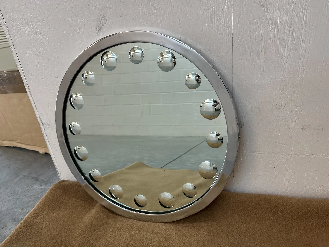 round antique mirror with decorative balls around it
