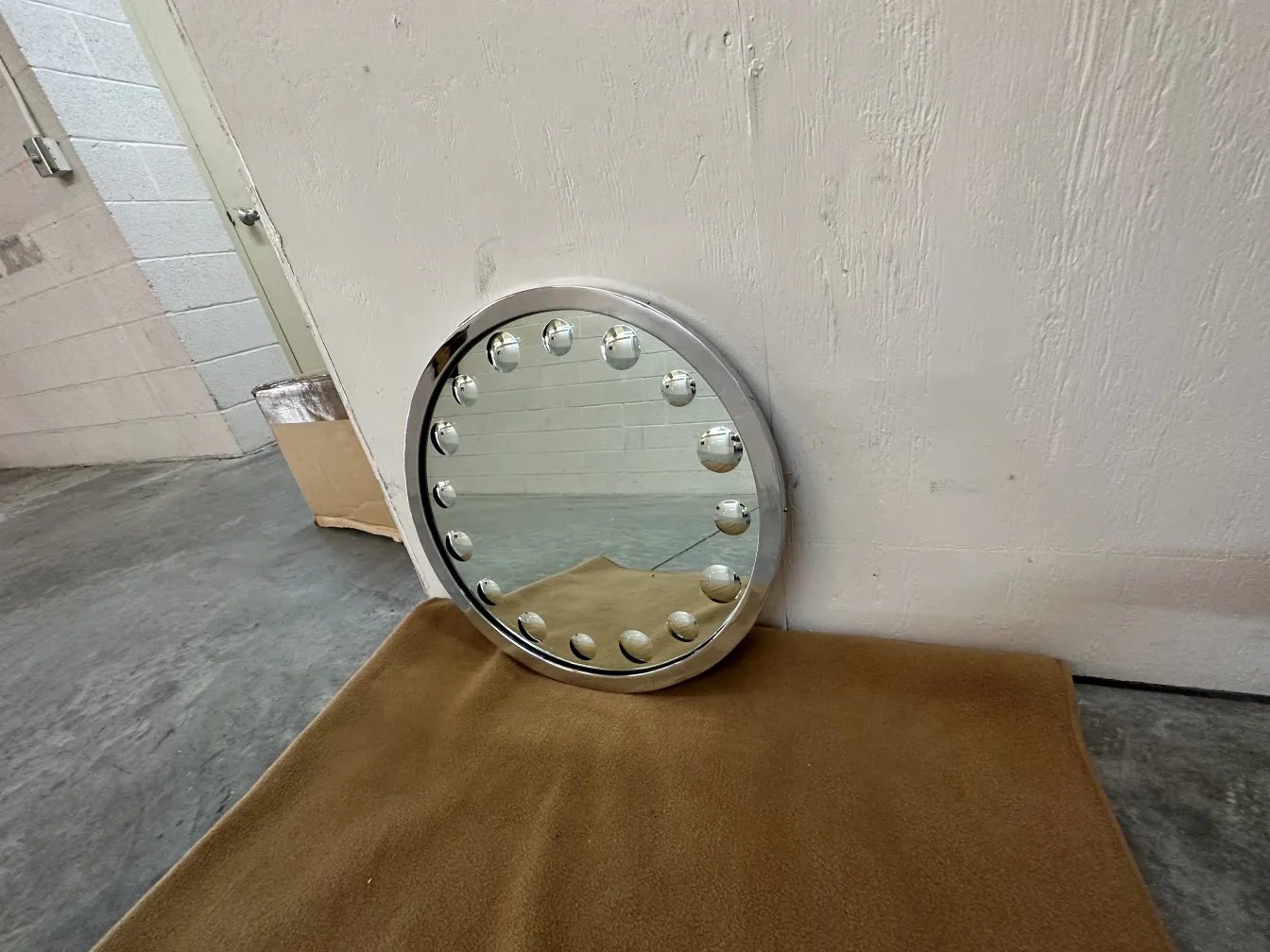 round antique mirror with lights around and soft background