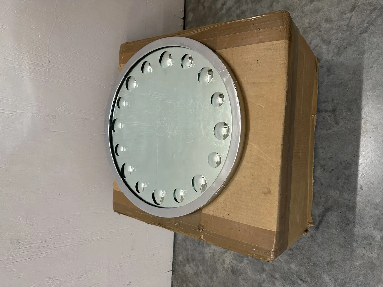 miroir ancien rond avec éclairage autour, présenté