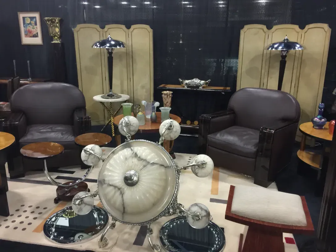 2 espejos antiguos reflejando una habitación acogedora, con muebles oscuros y una lámpara elegante