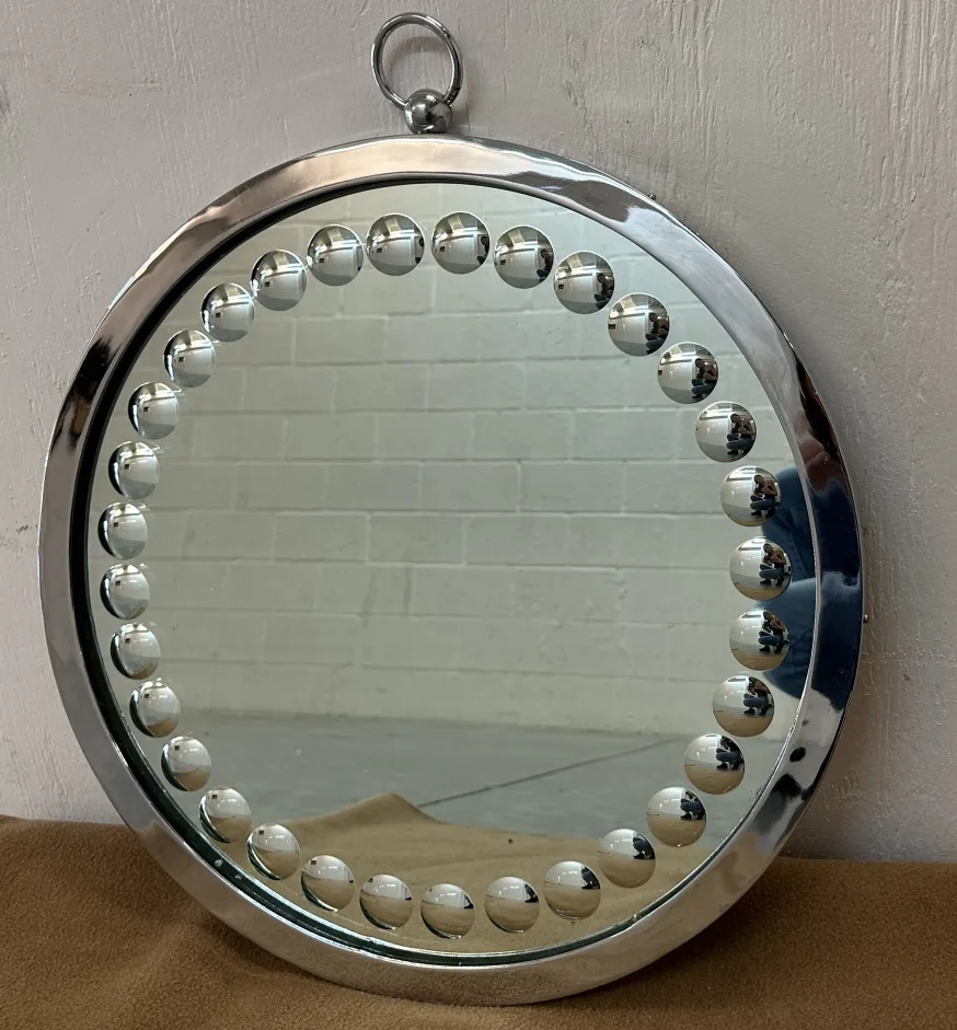 Antique mirrors with spherical details on the frame, in neutral setting.