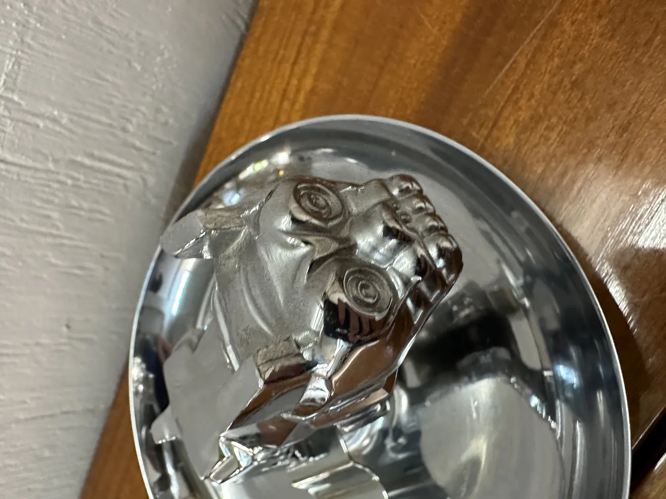 cenicero antiguo con diseño de cabeza, brillo metálico