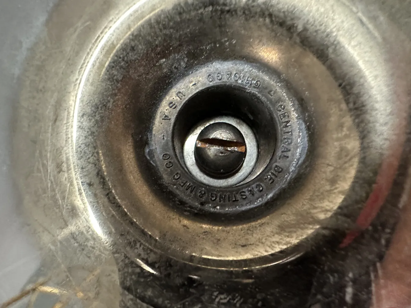 منفضة سجائر قديمة بتصميم دائري ومركز بارز في بيئة مهملة